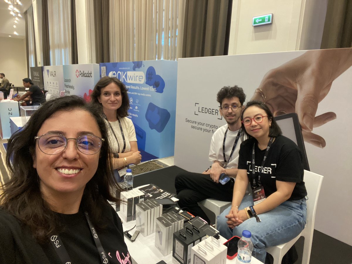 Burcu, Istanbul Blockchain Week 2025’te Ledger standında üç çalışma arkadaşıyla selfie çekiyor